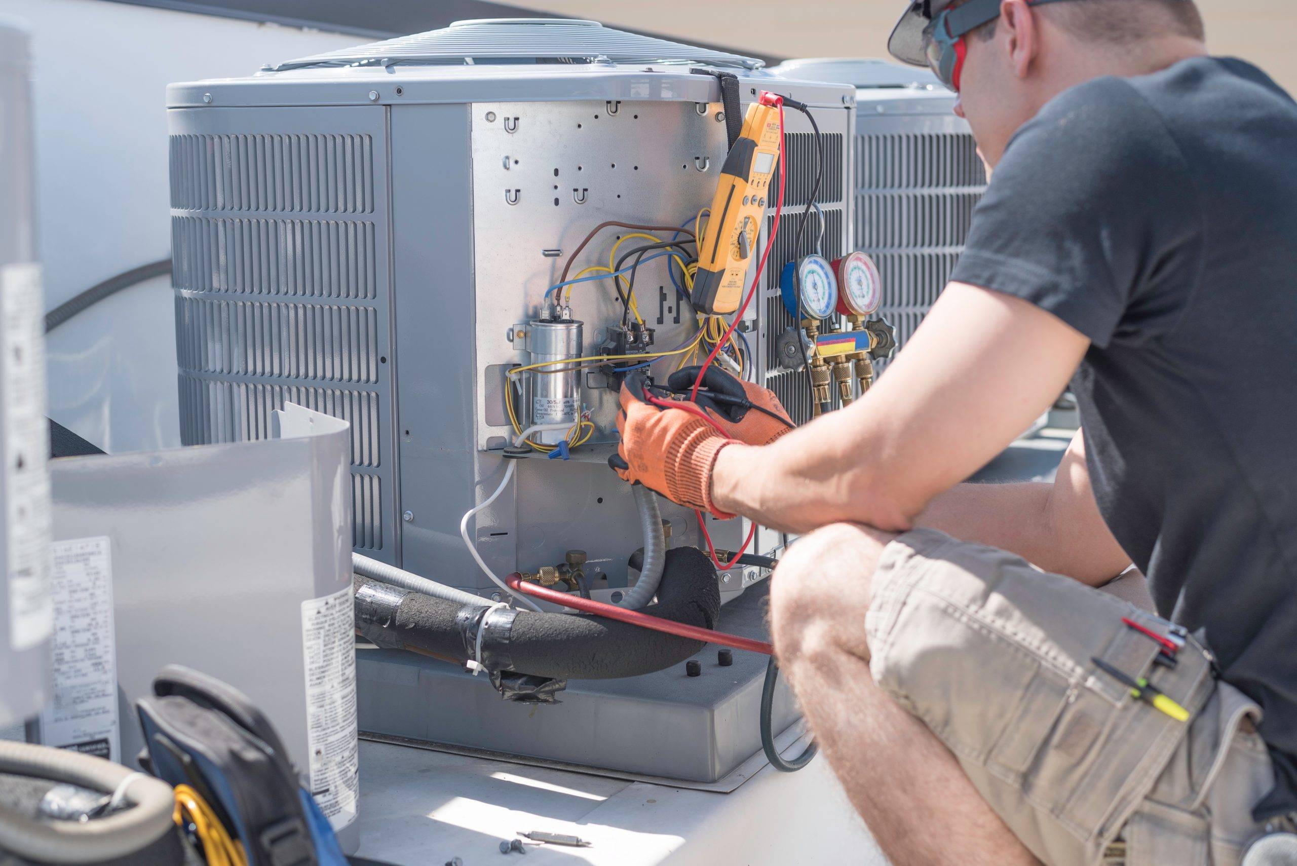 Hvac Technician Working On Controls Of Air Conditioner