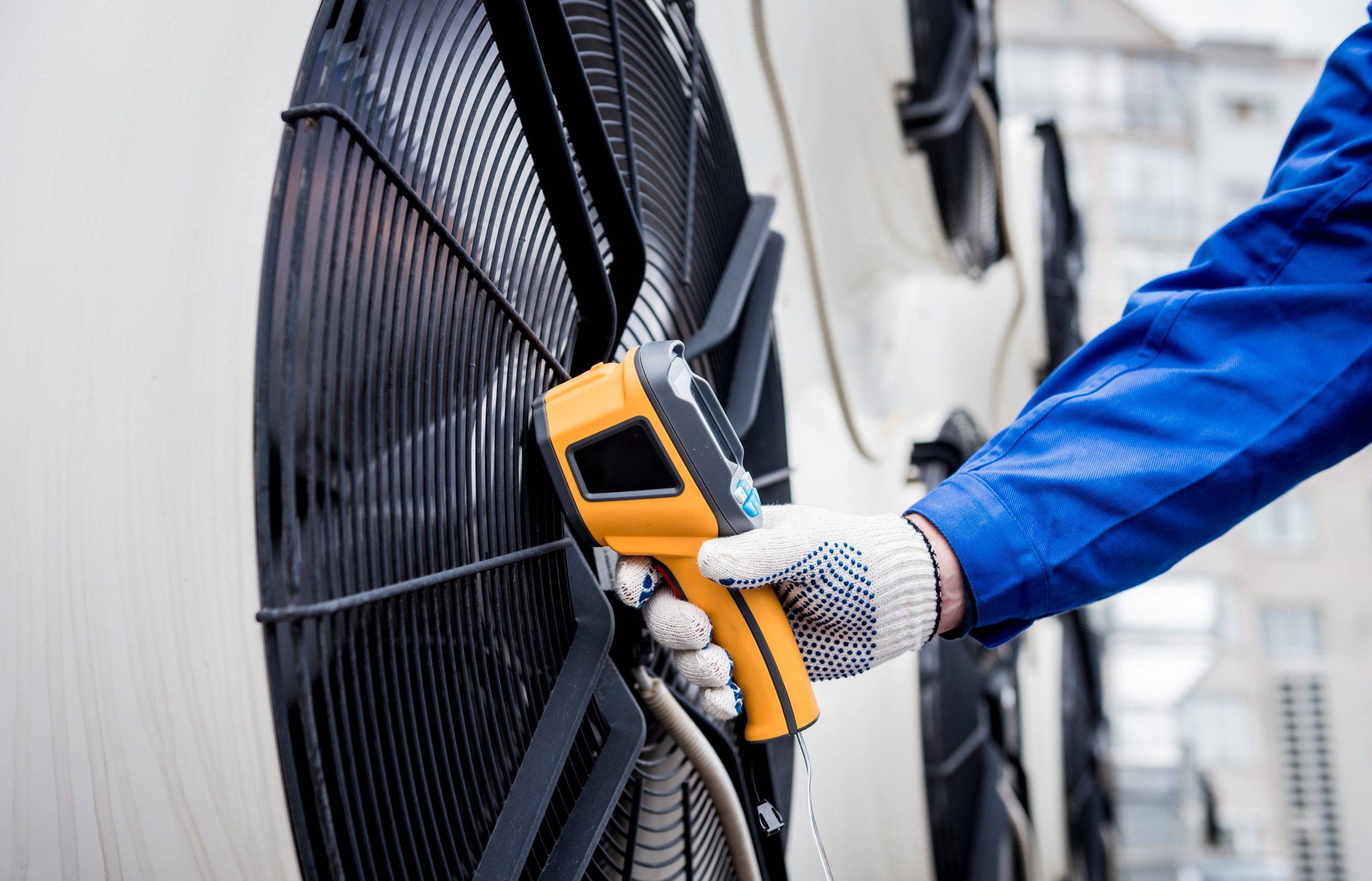 Technician Uses A Thermal Imaging Infrared Thermometer To Check The Condensing Unit Heat Exchanger.